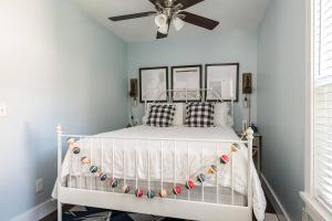 una camera con letto bianco e ventilatore a soffitto di The Little Haven - Charming Coastal Cottage a South Haven