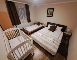 a bedroom with two beds and a crib in it at Villa Sunset in Palić +109 photos