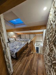 a room with two beds and a stone wall at ATLANTIS in Le Fousseret
