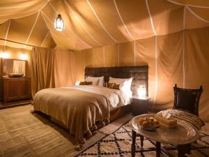 A bed or beds in a room at Luxury Merzouga Desert Camp
