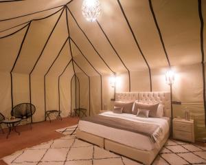 A bed or beds in a room at Luxury Merzouga Desert Camp