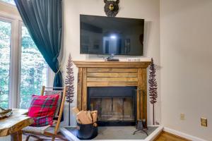 a living room with a fireplace with a tv above it at Wintergreen Resort Condo with Deck, 0 3 Mi to Slopes in Lyndhurst