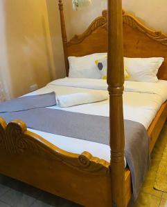 two beds with wooden posts in a room at Villa Serene Hotel in Kitale