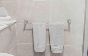 a bathroom with white towels hanging on a towel rack at Glasgow City - 1 Bedroom Apartment in Glasgow