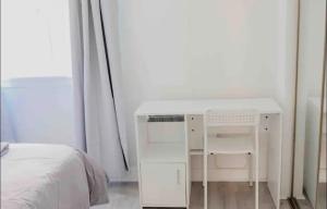 a white desk in a bedroom next to a bed at Glasgow City - 1 Bedroom Apartment in Glasgow +8 photos