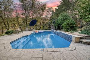 een zwembad met een parasol in de achtertuin bij 9BDRM Toccoa River Estate with Pool and Games in Mineral Bluff