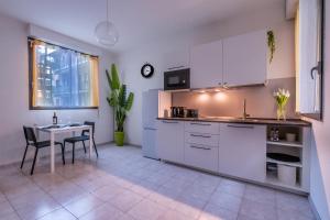 a kitchen with white cabinets and a table at My little house in Milan