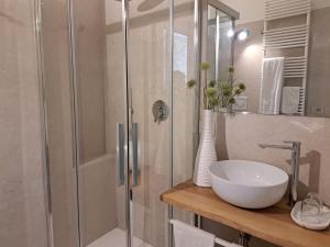 a bathroom with a glass shower with a sink and a toilet at Residenza Sant'Angelo in Spello