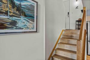 a staircase with a painting on the wall at Freshly Remodeled - 2 King Beds- Breathtaking Views in Canmore +34 photos