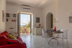 a living room with a red couch and a table at Dolce Vita Beach House stunning views by the sea in Capri