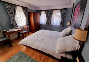 a bedroom with a large white bed and a desk at QC5 Pension Buchen in Odenwald in Buchen