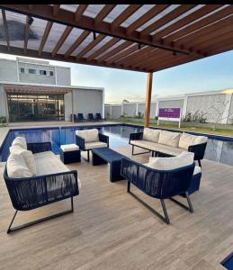 a patio with couches and tables and a swimming pool at Apartamento Studio 003 in Caruaru