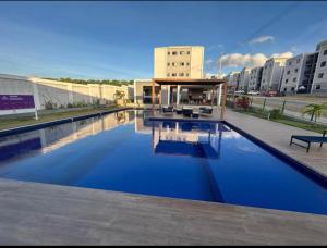 a large swimming pool with a building in the background at Apartamento Studio 003 in Caruaru