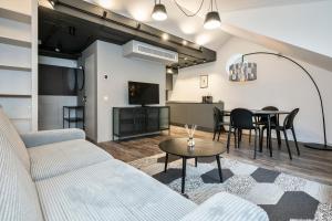 a living room with a couch and a table at Artsy Exclusive Old Town Residence Gallery Walk in Vilnius