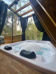 a jacuzzi tub in a room with a window at Reserva Linha Bonita - Chalés Românticos in Gramado
