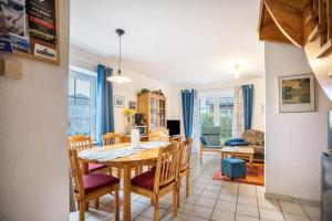 a dining room and living room with a table and chairs at Haus Clara in Neßmersiel