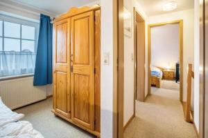 a bedroom with a closet and a bed and a window at Haus Clara in Neßmersiel