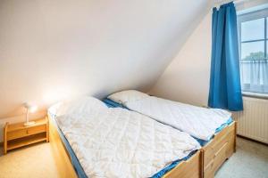 a small bedroom with a bed and a window at Haus Clara in Neßmersiel +18 photos