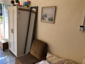 a living room with a chair and a mirror at Converted Shed Studio & Garden Hanging Bed in Porto Rafti