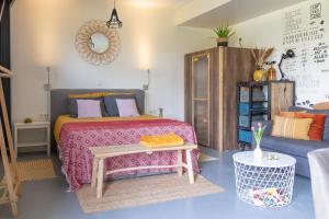 a bedroom with a bed and a table and a couch at B&B De Achterdiek in Ruinen