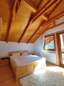 une chambre avec un lit et un plafond en bois dans l'établissement Cottage Piatra Craiului, à Zărneşti