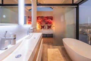 Un baño con bañera y un dormitorio. en Penthouse with a view to die for!, en Ciudad del Cabo