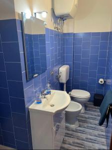 een blauw betegelde badkamer met een wastafel en een toilet bij da Paolone in Deiva Marina