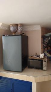 eine Küche mit einer Mikrowelle und einem Kühlschrank in der Unterkunft Studio duplex pierre bleue in Asilah