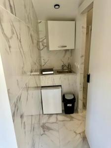 a bathroom with white marble walls and a sink at Appartement 1 - Orsay, France in Orsay