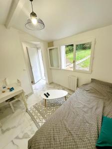 a bedroom with a bed and a table and a window at Appartement 1 - Orsay, France in Orsay
