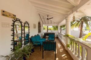 um alpendre com cadeiras azuis e uma mesa em Villa Baywalk Goa em Morjim
