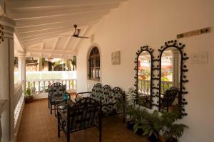 a dining room with chairs and a table on a porch at Villa Baywalk Goa - 200 meters from Morjim Beach in Morjim