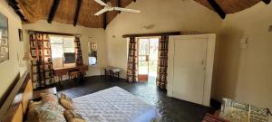 a bedroom with a bed and a door in a room at Matopo Ingwe Lodge in Matopos
