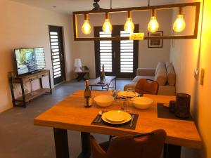 a living room with a wooden table with chairs and lights at KasDes Bonaire in Kralendijk