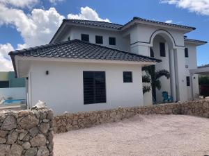 a white house with a stone fence in front of it at KasDes Bonaire in Kralendijk