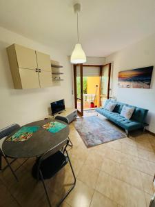 a living room with a blue couch and a table at Appartamento Nonno Pino a 50m dal mare in Senigallia