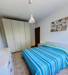 a bedroom with a bed and a painting on the wall at Appartamento Nonno Pino a 50m dal mare in Senigallia