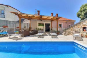 a patio with a swimming pool and a house at Holiday home in Novi Vinodolski 45274 in Novi Vinodolski