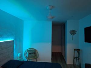a blue room with a bed and a chair at Chez Marine ô Marines in Saint-François +11 photos