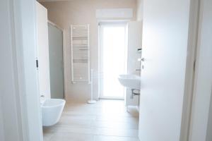 a white bathroom with two sinks and a toilet at The Moon in Monopoli
