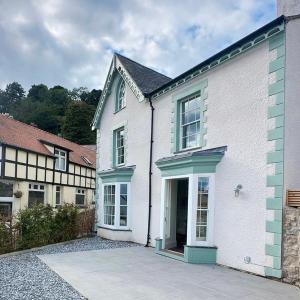 a white house with a driveway in front of it at Family Holiday Home by the Great Orme Tramway and Beach in Llandudno