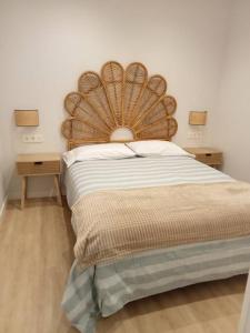 a bed with a large wooden headboard in a bedroom at Luminoso piso con vistas al Puerto in Castro-Urdiales