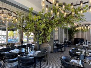 un ristorante con tavoli, sedie e un lampadario di Radisson Collection Astorija Hotel, Vilnius a Vilnius