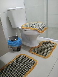 a bathroom with a toilet and two rugs on the floor at FLAT próximo ao mar in Cabedelo +11 photos
