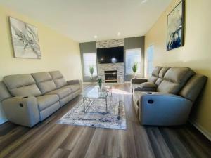 a living room with two couches and a table at Wonderful 4BR Home in Grafton
