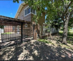 a gate in front of a house with a tree at Casa en Pueblo Esther in General Lagos