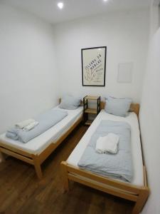 two twin beds in a room with white towels at Apartment central in Bad Saulgau