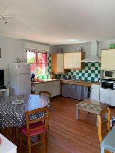 una cucina con tavolo, sedie e tavolo e una cucina con tavolo di Gîte 1 chambre adapté PMR a Saint-Amand-les-Eaux