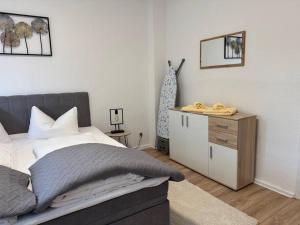 ein Schlafzimmer mit einem Bett und einer Kommode darin in der Unterkunft Gemütliche Wohnung direkt am Bahnhof zentrale Lage in Bitterfeld