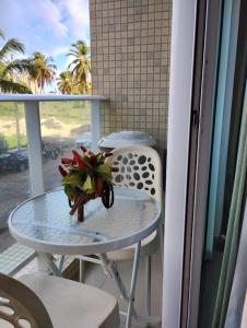 a table with a flower arrangement on a balcony at FLAT próximo ao mar in Cabedelo